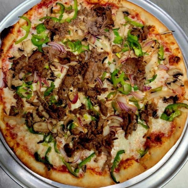Cedar's Pizza with steak, green peppers, mushrooms, and red onions on a metal tray.